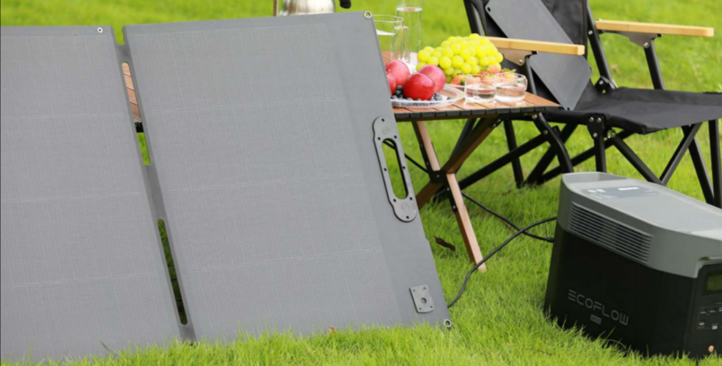Portable solar panel charging an outdoor power station at camp